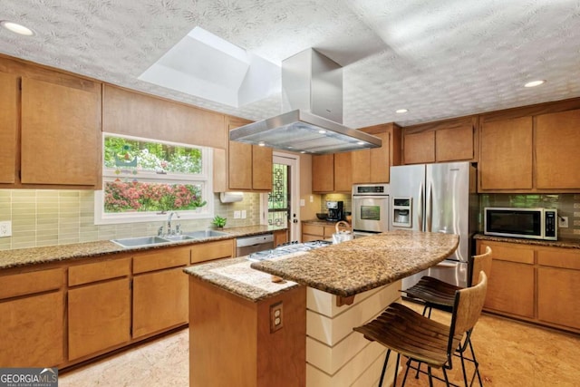 kitchen with a sink, tasteful backsplash, range hood, light stone countertops, and appliances with stainless steel finishes