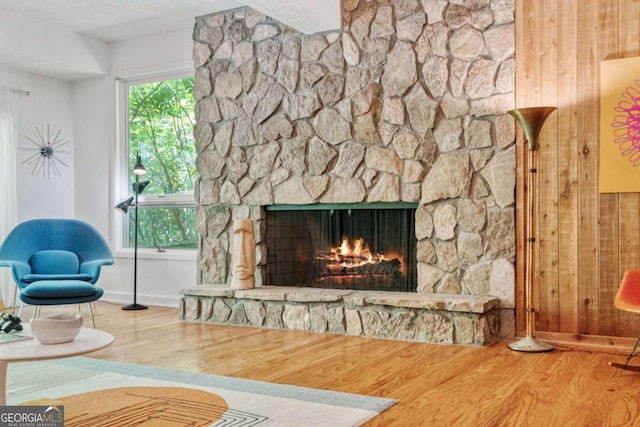 living room featuring baseboards, wood finished floors, and a fireplace