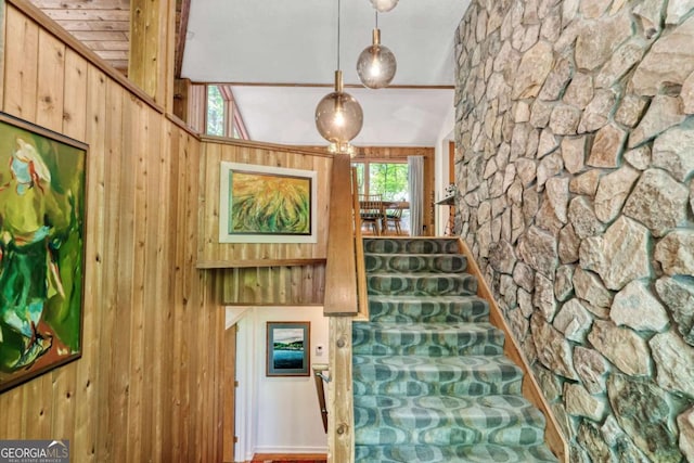 stairway featuring wooden walls