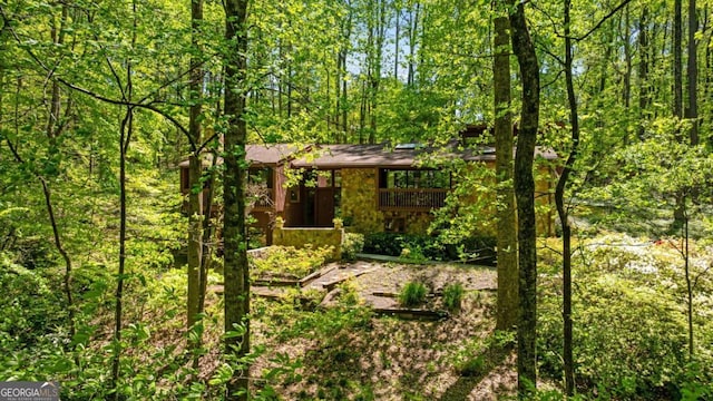 view of front of property featuring a view of trees