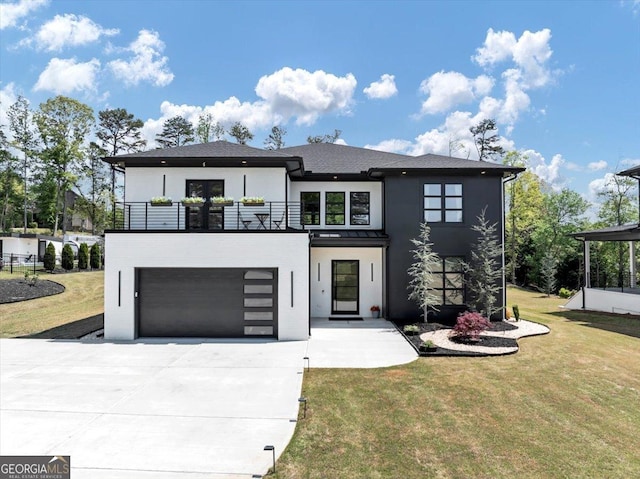 modern home featuring a front lawn, driveway, a balcony, and stucco siding