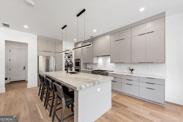 kitchen featuring stainless steel appliances, a kitchen breakfast bar, visible vents, modern cabinets, and gray cabinets