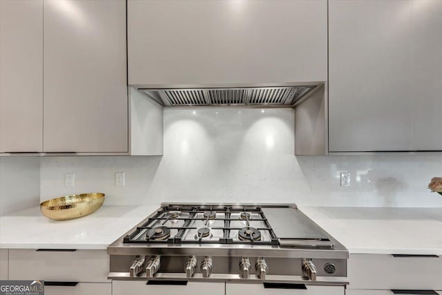 room details featuring light countertops, stainless steel gas cooktop, decorative backsplash, and gray cabinetry