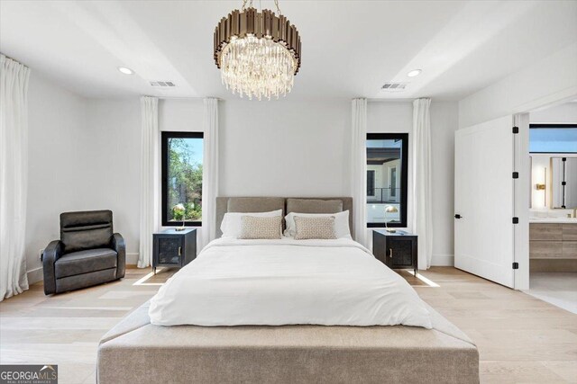 bedroom with a chandelier, wood finished floors, visible vents, and recessed lighting