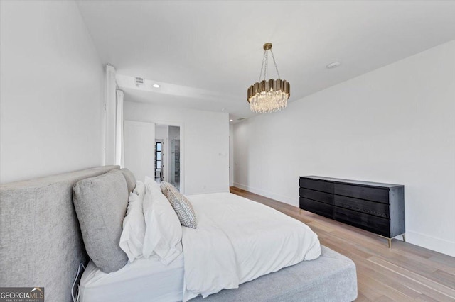 bedroom featuring recessed lighting, baseboards, an inviting chandelier, and light wood-style flooring