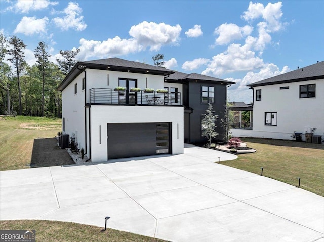 view of front of home featuring a balcony, driveway, a front yard, a garage, and stucco siding