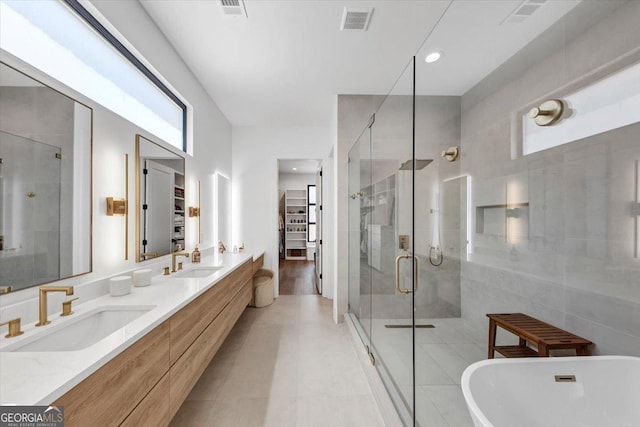 bathroom with a shower stall, a soaking tub, a sink, and visible vents