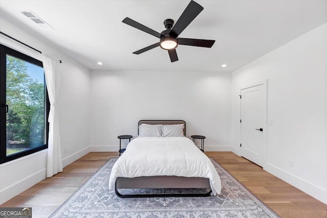 bedroom featuring baseboards, light wood-style floors, visible vents, and recessed lighting