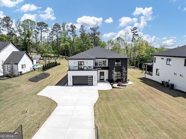 view of front facade featuring a balcony, driveway, an attached garage, a front yard, and stucco siding