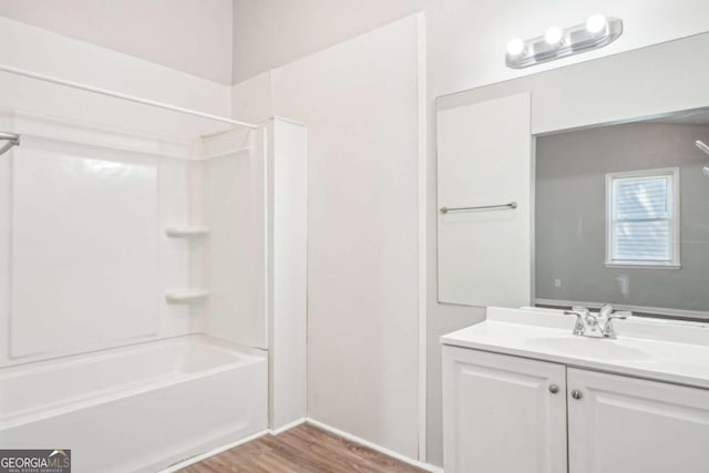 bathroom with shower / bath combination, wood finished floors, and vanity