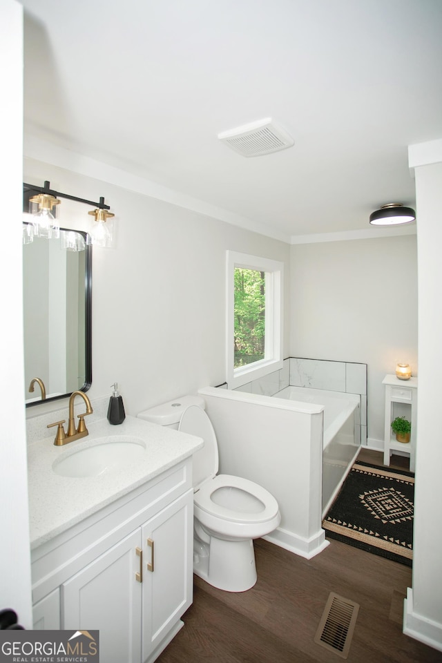 216 Howard Rd, Barnesville, GA 30204 - bathroom with wood finished floors, vanity, a bath, toilet, and ornamental molding