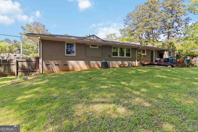 rear view of property featuring fence, crawl space, a lawn, and central air condition unit