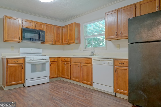 1166 Memory Ln, Lawrenceville, GA 30044 - kitchen with black appliances, a sink, ornamental molding, light countertops, and light wood-type flooring