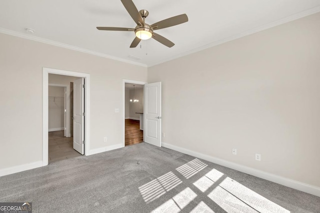 130 Magnolia Pl, Homer, GA 30547 - unfurnished bedroom featuring ornamental molding, carpet, a walk in closet, and ceiling fan