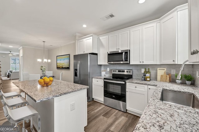 130 Magnolia Pl, Homer, GA 30547 - kitchen with appliances with stainless steel finishes, crown molding, wood finished floors, white cabinetry, and recessed lighting