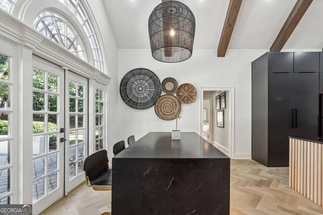 dining space with beam ceiling, baseboards, and a high ceiling