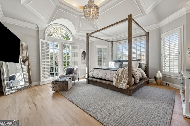 bedroom featuring a chandelier, wood finished floors, baseboards, and ornamental molding