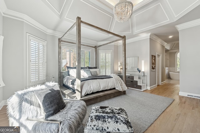 bedroom with a notable chandelier, wood finished floors, baseboards, ornamental molding, and visible vents