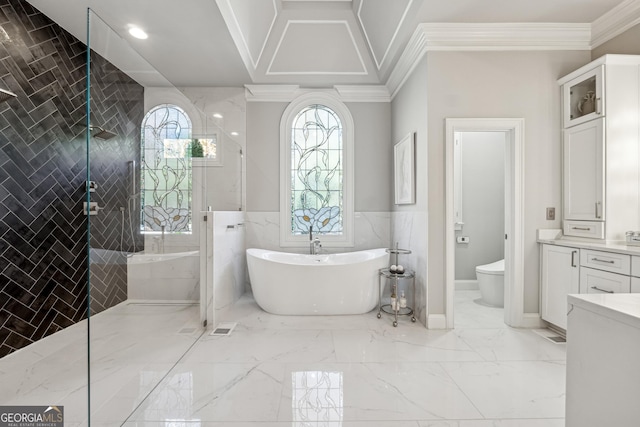 full bathroom with tile walls, a freestanding tub, marble finish floor, and crown molding