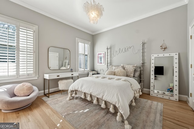 bedroom with wood finished floors, baseboards, and crown molding