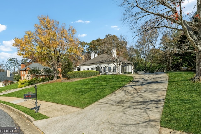 ranch-style house featuring driveway and a front yard
