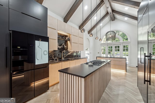 kitchen featuring stainless steel gas cooktop, dark countertops, modern cabinets, light brown cabinets, and a kitchen island