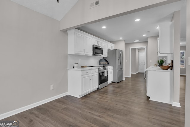 kitchen featuring light countertops, visible vents, dark wood-style floors, and stainless steel appliances