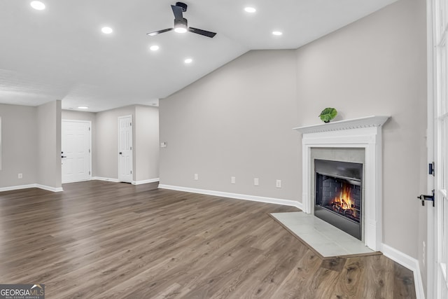 unfurnished living room with a fireplace with flush hearth, baseboards, wood finished floors, and ceiling fan