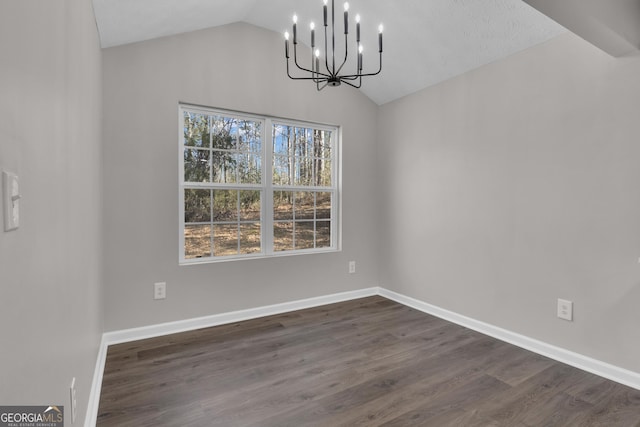 unfurnished dining area featuring baseboards, vaulted ceiling, dark wood-style floors, and a notable chandelier