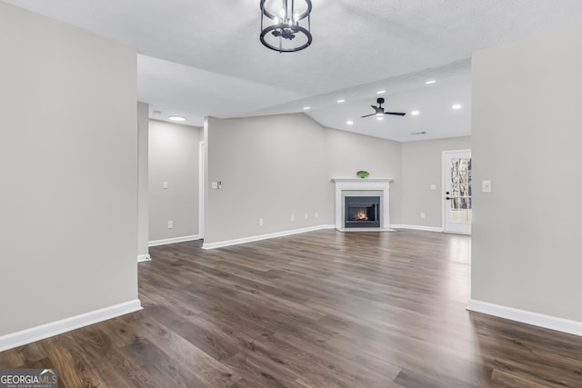 unfurnished living room featuring a fireplace with flush hearth, baseboards, recessed lighting, and ceiling fan with notable chandelier