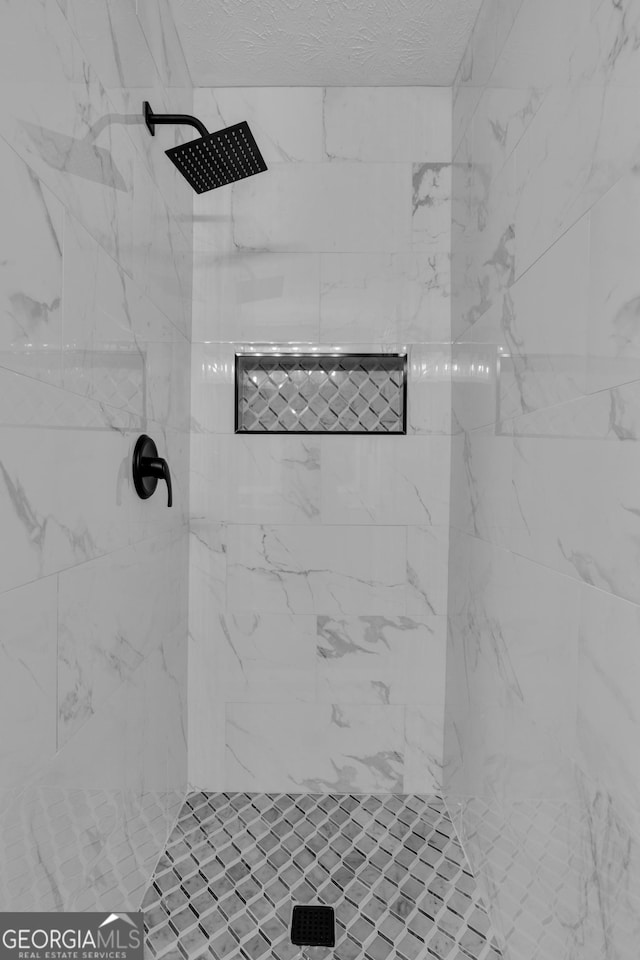 full bath featuring tiled shower