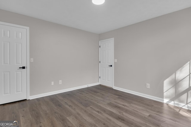 empty room featuring baseboards and wood finished floors