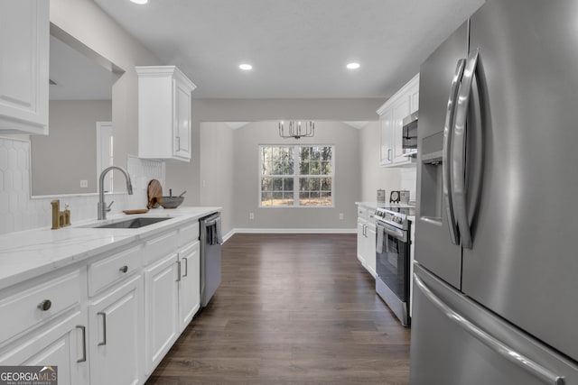 kitchen featuring a sink, decorative backsplash, stainless steel appliances, white cabinetry, and dark wood-style floors