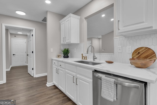 kitchen with white cabinets, a sink, backsplash, light stone countertops, and dishwasher