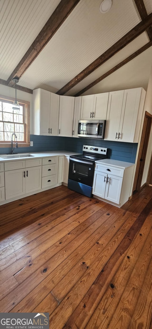 kitchen with a sink, stainless steel microwave, dark wood-style flooring, white cabinetry, and electric range oven
