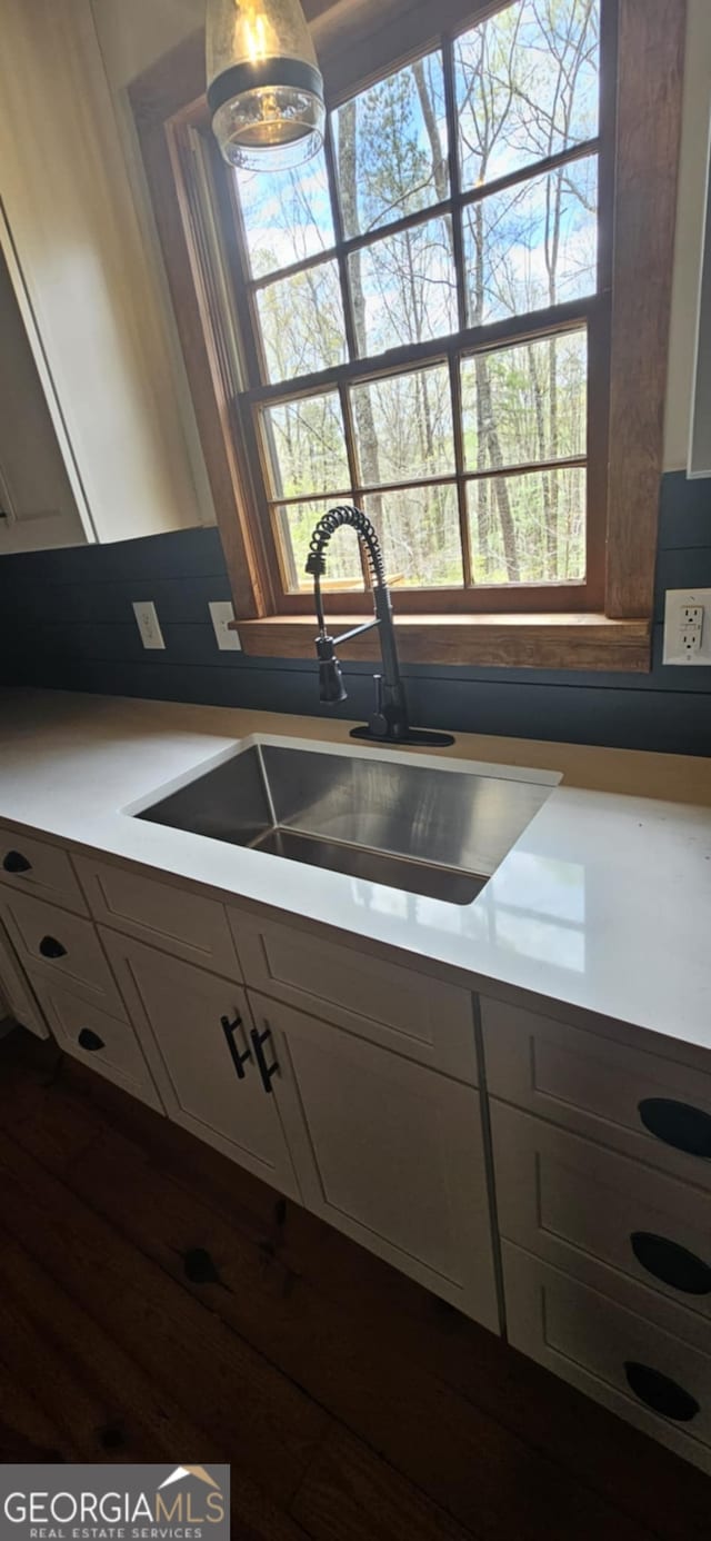 kitchen with white cabinets, a sink, and plenty of natural light