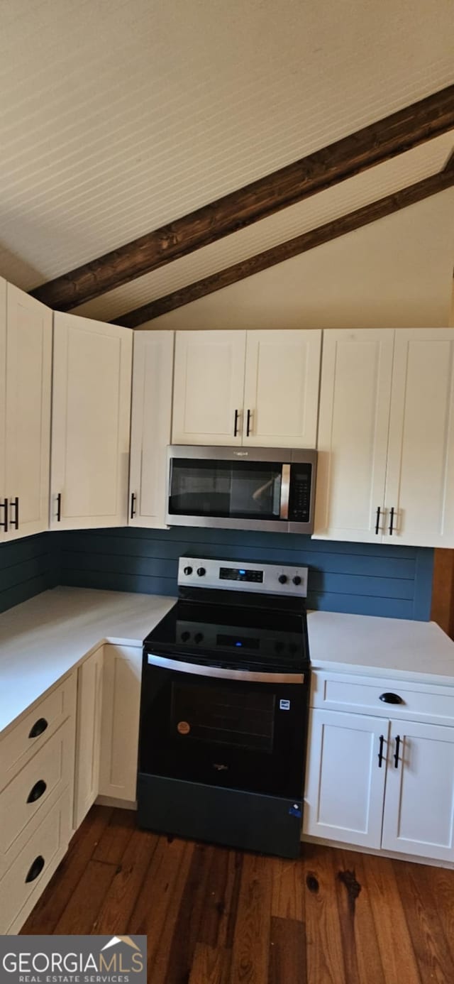 kitchen featuring stainless steel microwave, electric range oven, white cabinetry, and light countertops
