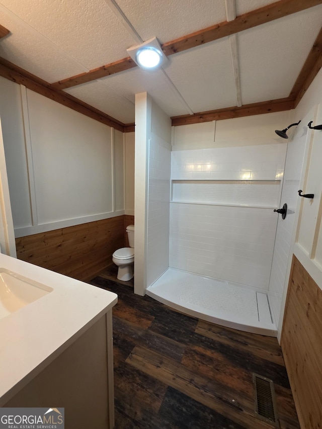 bathroom featuring a stall shower, toilet, visible vents, wood finished floors, and vanity