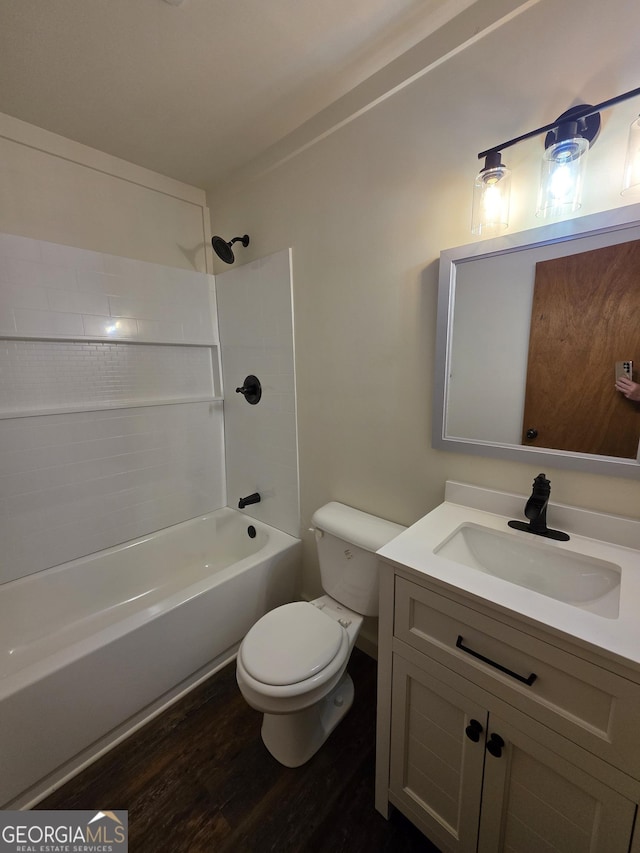 full bath featuring wood finished floors, toilet, vanity, and bathing tub / shower combination