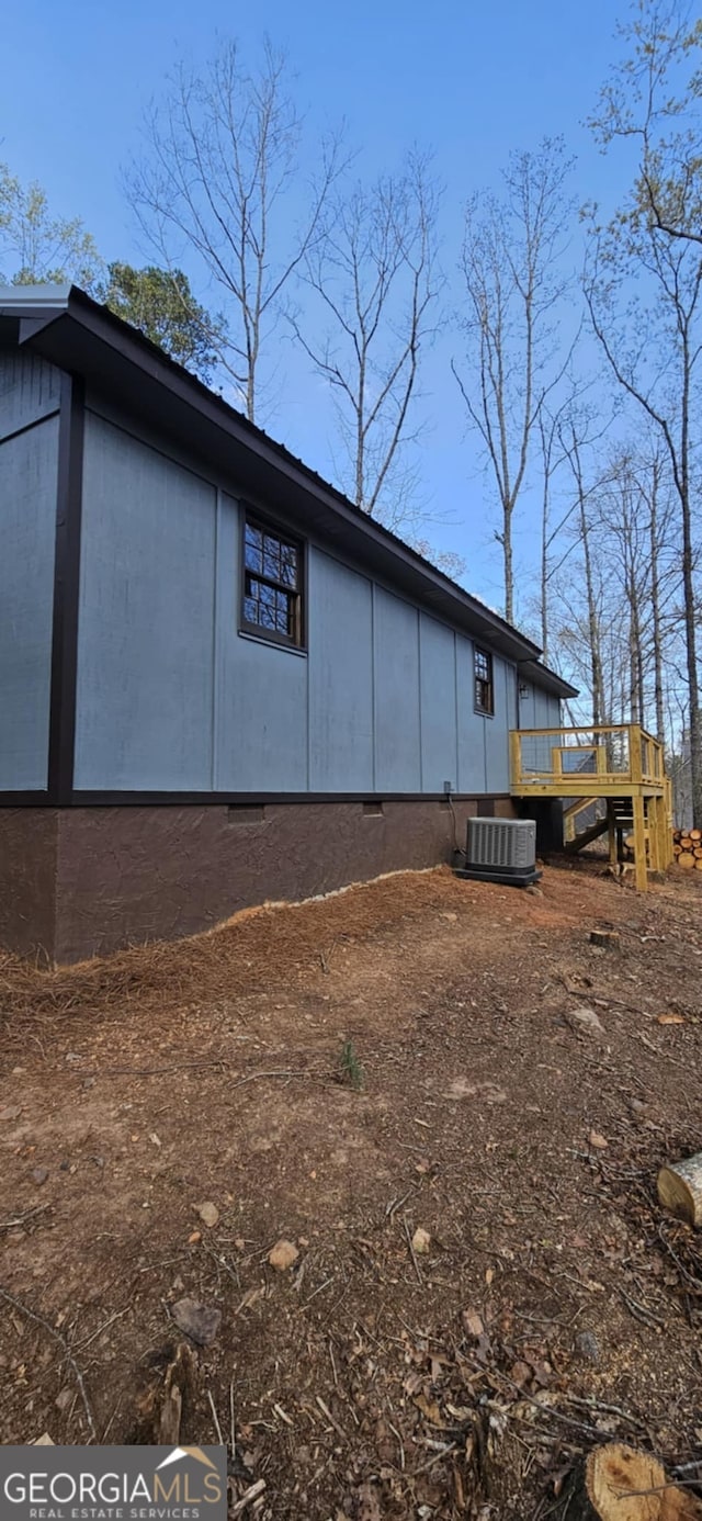 back of property with central air condition unit, crawl space, and a deck