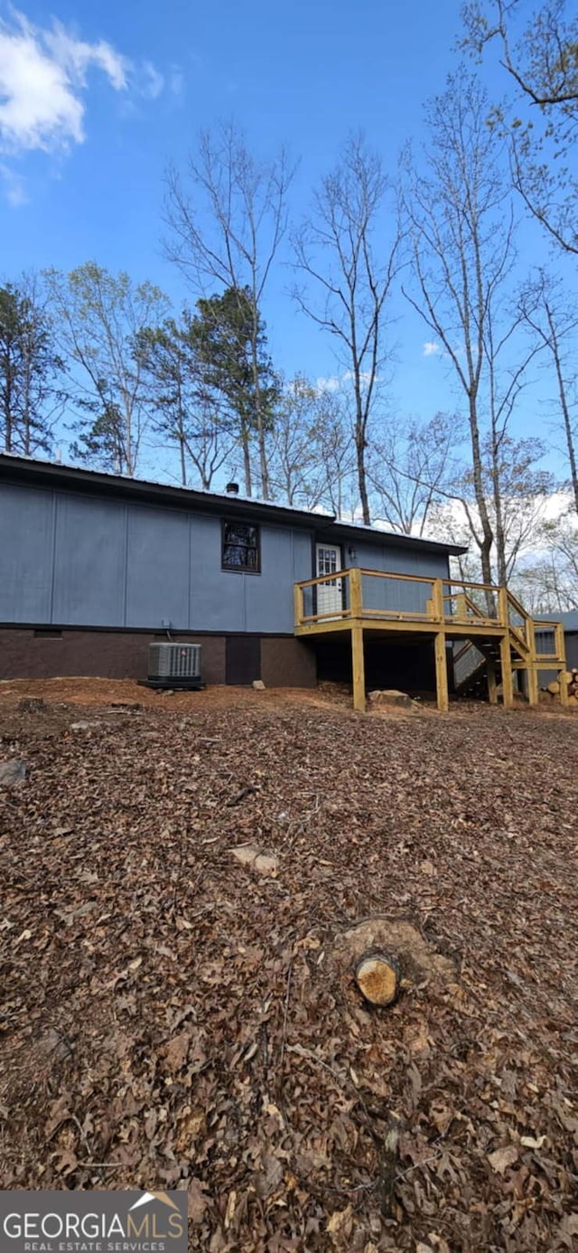 back of house with a deck and cooling unit