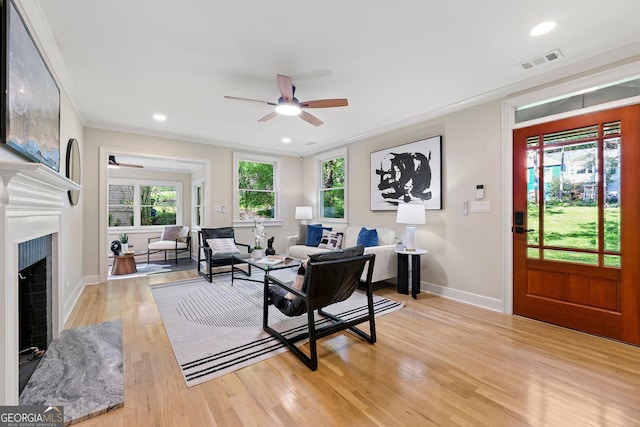 1186 Thomas Rd, Decatur, GA 30030 - living area featuring a ceiling fan, baseboards, light wood-style floors, a fireplace with raised hearth, and ornamental molding