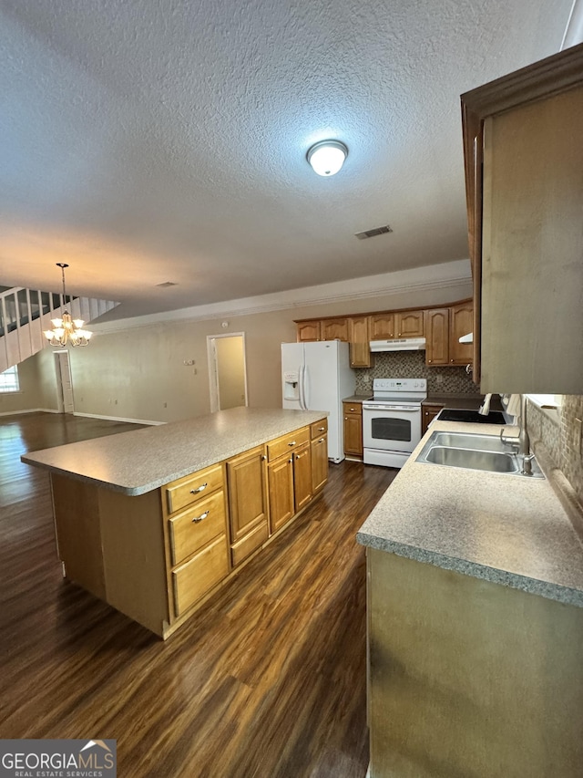 kitchen featuring dark wood finished floors, under cabinet range hood, visible vents, a sink, and white appliances