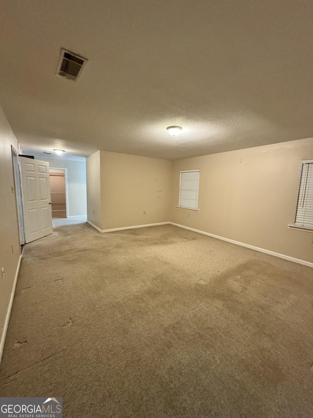 unfurnished room with baseboards, light carpet, and visible vents