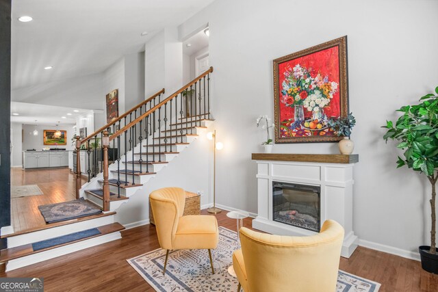 1954 Timothy Dr NE, Atlanta, GA 30329 - living area featuring wood finished floors, a glass covered fireplace, stairway, baseboards, and recessed lighting