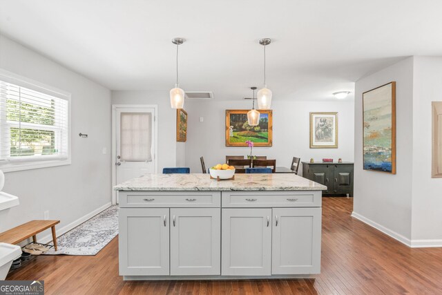 1954 Timothy Dr NE, Atlanta, GA 30329 - kitchen featuring baseboards, wood finished floors, decorative light fixtures, light stone counters, and a center island