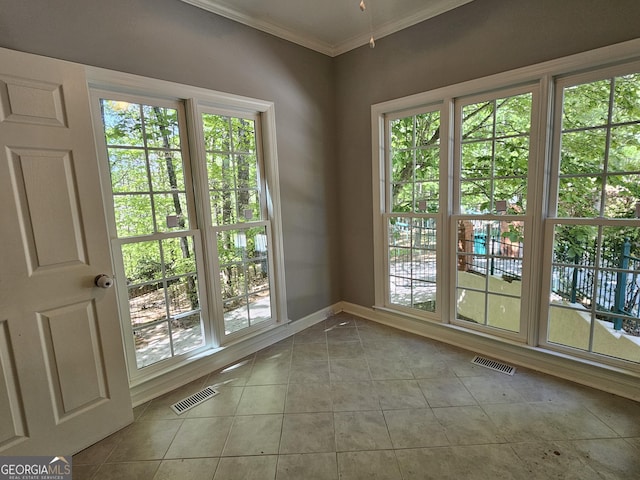 doorway with visible vents, tile patterned flooring, baseboards, and ornamental molding