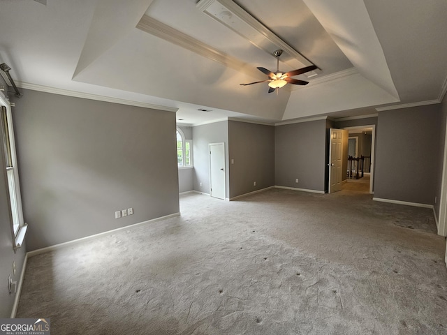 unfurnished living room with ornamental molding, carpet floors, a ceiling fan, and a tray ceiling