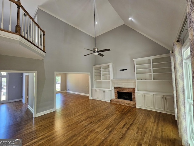 unfurnished living room with plenty of natural light, a ceiling fan, wood finished floors, and a fireplace