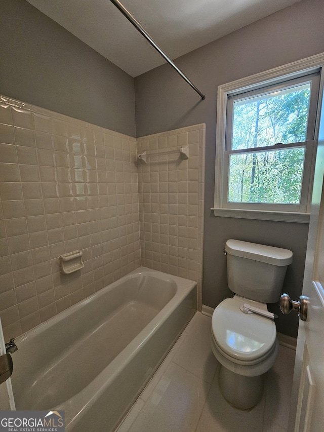 full bath featuring bathing tub / shower combination, toilet, tile patterned floors, and baseboards
